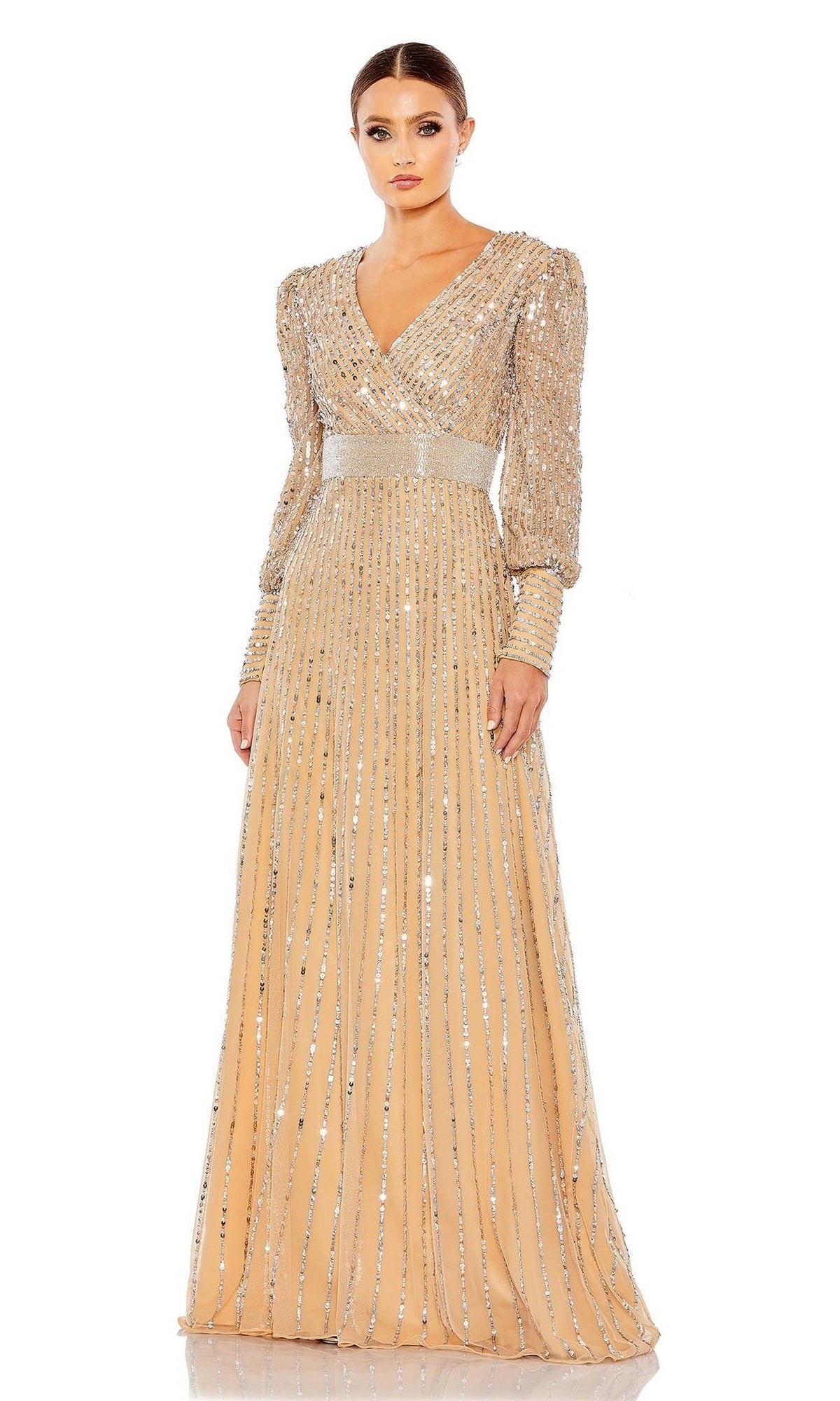 A woman stands against a plain white background wearing the Mac Duggal 5720, a long sleeve sequin formal dress with silver stripes and a v-neckline—perfect as a mother of the bride evening gown.